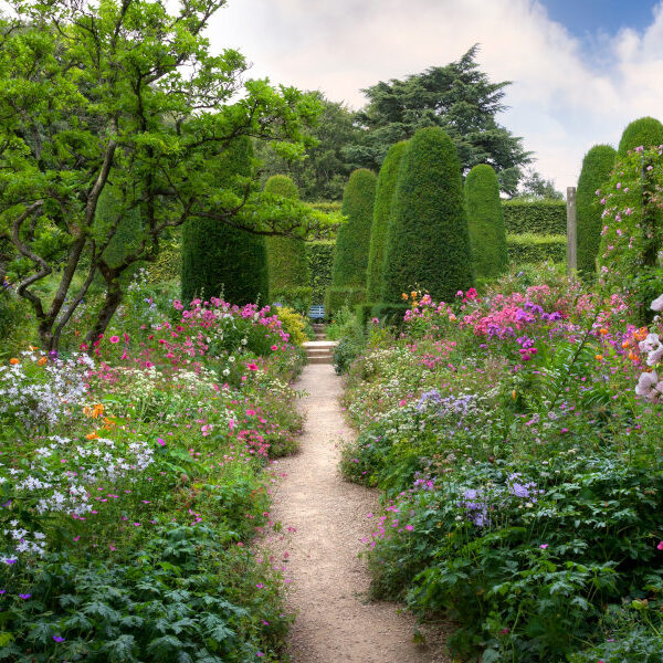 Ein Weg führt durch einen üppig blühenden Cottage Garten