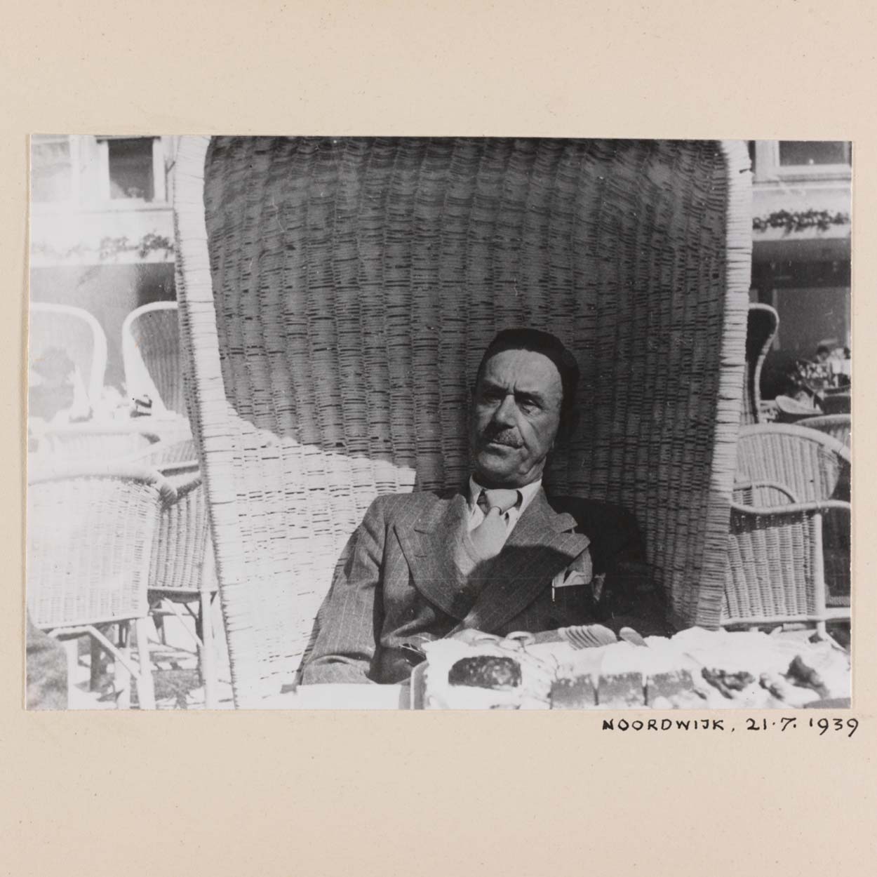 Zu sehen ist ein mit Ort und Datum unterschriebenes Foto des Schriftstellers Thomas Mann, der in einem Strandkorb sitzt.